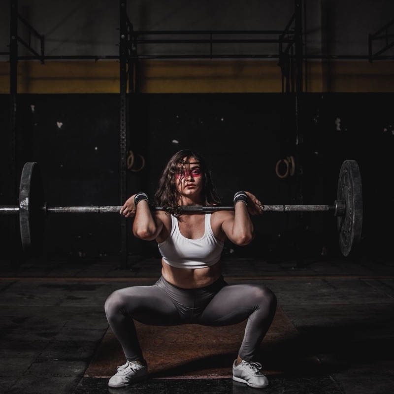 A lifter at the bottom of a front squat with a loaded bar.